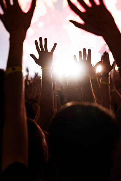 istock Silhouetted hands raised in worship or celebration at concert 2263125783