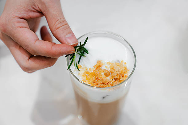 Hand Garnishing Specialty Iced Latte With Rosemary