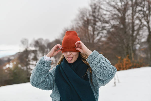 Elegant lady enjoying the winter snow outdoors