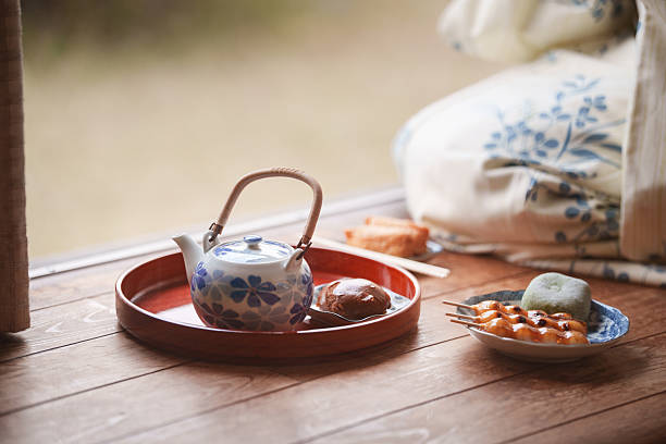 Japanese tea set with traditional sweets served on a tray on the wooden engawa veranda of a traditional Japanese house.