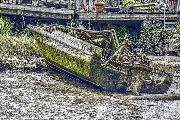 Unrepairable boat sitting in the low tide mud. Location is Ladner, British Columbia, Canada.