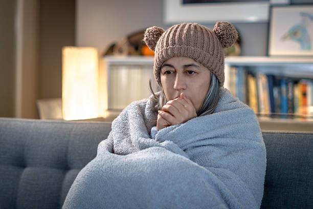 istock Woman shivering, wrapped in blanket, feeling cold, ill 2263205199