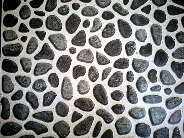 A symbol of the sun with rays, laid out from smooth sea pebbles on a white surface