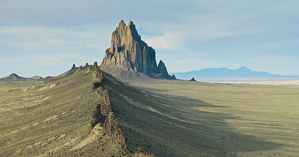 Aerial photograph of the dramatic Ship Rock, a 1700-foot tall, 27-million year old volcanic formation in San Juan County, New Mexico. It is a sacred site and plays a significant role in Navajo religion, myth, and tradition.