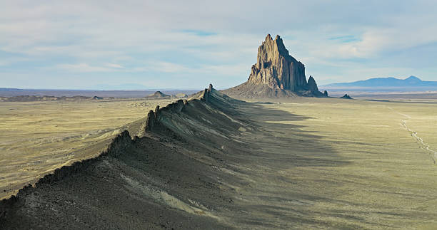 Aerial photograph of the dramatic Ship Rock, a 1700-foot tall, 27-million year old volcanic formation in San Juan County, New Mexico. It is a sacred site and plays a significant role in Navajo religion, myth, and tradition.
