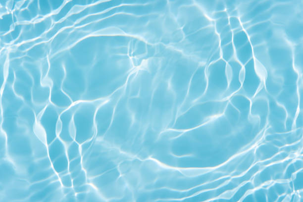 Bright and refreshing image of clean turquoise water with sun reflections and light ripples. Perfect as a summer background, spa theme, or vacation concept.