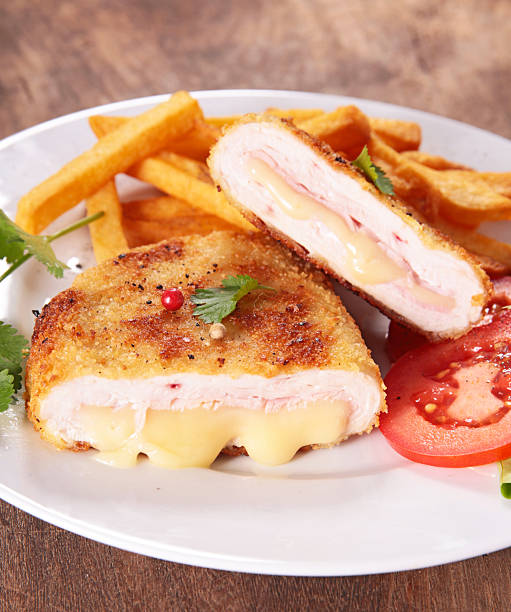 delicious chicken cordon bleu served with french fries. fried chicken fillet with ham and melted cheese