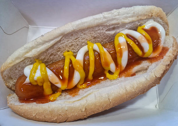 Hot dog with mustard, tomatoes, leaves and sausage