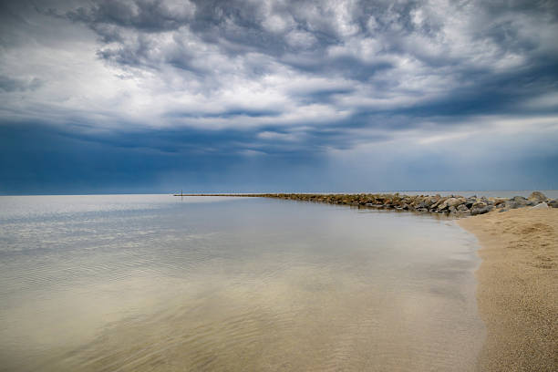 Storm clouds over a dam in the IJsselmeer during a springtime day along the IJsselmeer lakeshore.