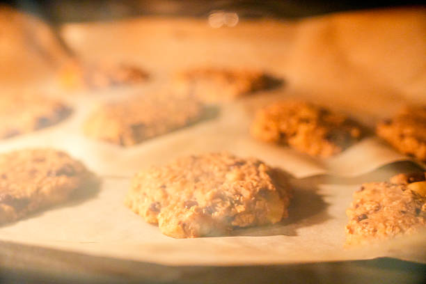 A tray of cookies is baking in an oven. The cookies are golden brown and appear to be ready to be taken out