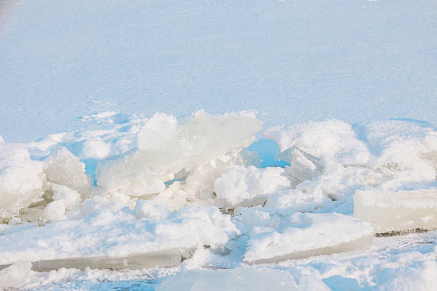Intricate patterns formed by jagged ice and powdery snow cover the expansive winter lake.