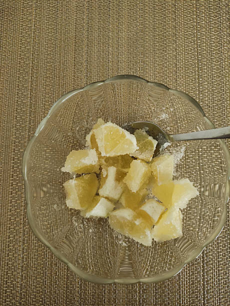 Brightly colored lemon-flavored gelatin cubes arranged in a glass bowl with a silver spoon resting beside them showcasing a delightful dessert experience