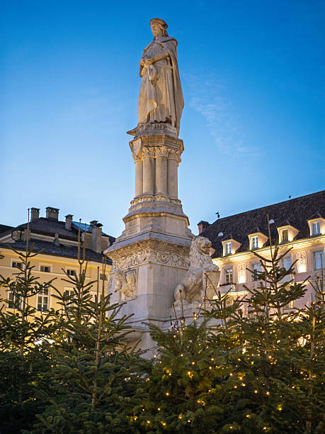Walther Von Der Vogelweide Statue Behind Illuminated Christmas Trees, Bolzano, Italy.