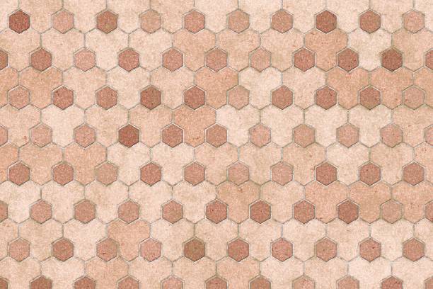 Overhead shot of peach colored hexagonal tiles with subtle natural stone textures and warm earthy tones.