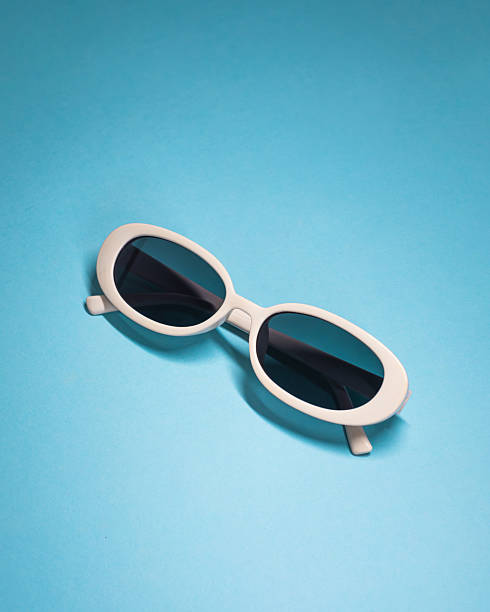 White oval sunglasses on blue background with copy space, clean studio lighting and soft shadow. Ideal for summer fashion ads, eyewear ecommerce, web headers, social banners, editorial, and blogs.