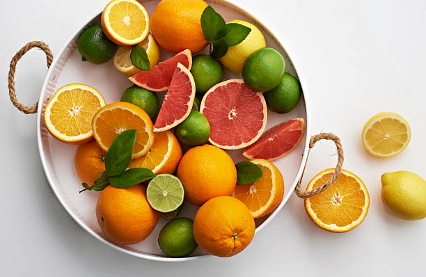 Oranges Grapefruit Limes in Nuetral White Tray Overhead Flat Lay