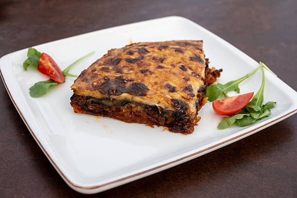 Traditional Macedonian moussaka baked casserole garnished with arugula and cherry tomatoes.