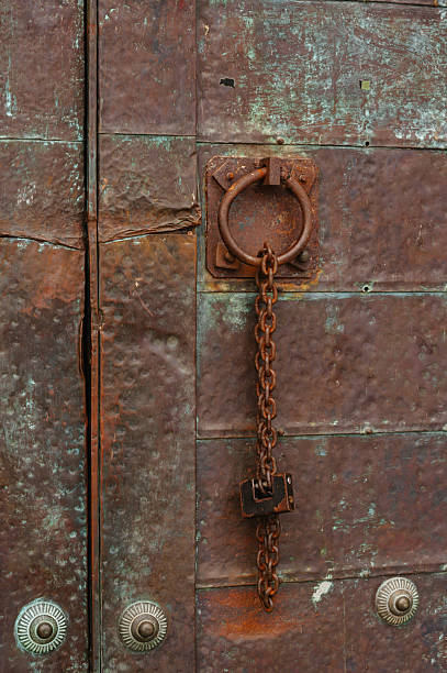 Rusted Fortress Gate With Hanging Lock And Chain, Heavy Iron Ring, Corroded Patina, Weathered Bolts,
