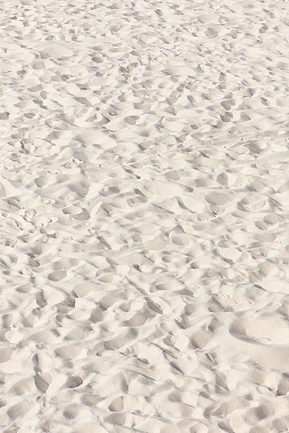 istock Close-up view of fine white sand with various footprints and textures, creating a natural pattern on a beach surface under bright sunlight 2263360443