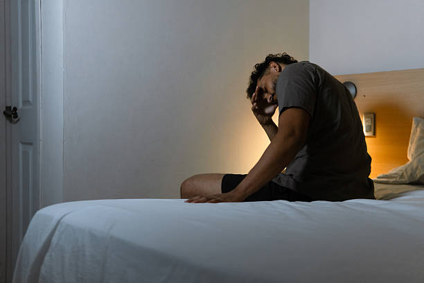 istock Man suffering from insomnia and stress sitting on bed at night 2263362465