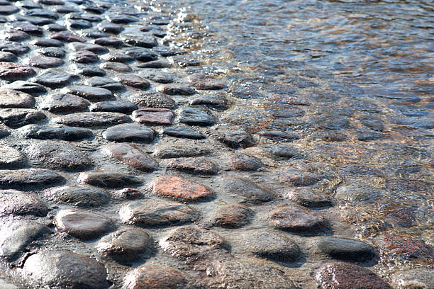 River embankment with water, granite stone paving, and reflected light