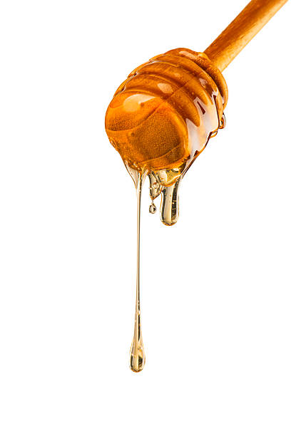 Golden Honey Dripping from Wooden Honey Dipper
