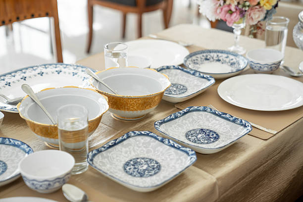 Elegant white ceramic crockery, expertly placed on the table, sets the stage for a memorable meal.