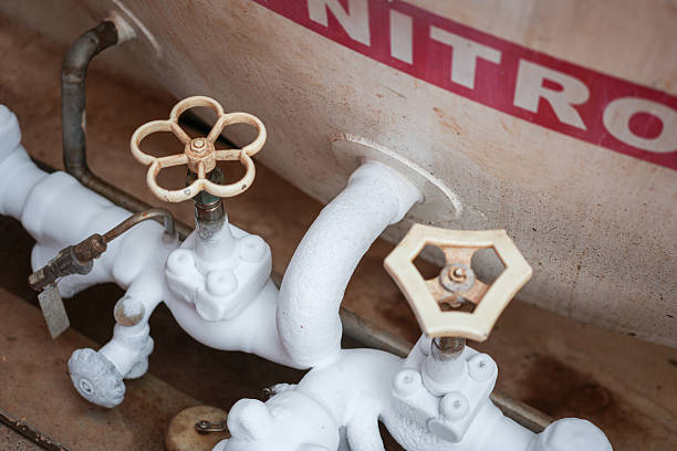 Liquid nitrogen, cryogenic chemical is flowing in rigid pipeline during transfer process. It is very super cooling temperature, cause iced frost on the pipeline surface during pumping. Close-up and selective focus.