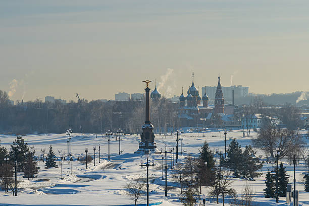 Wide winter panorama of snowy park and river area under clear sky. Suitable for seasonal and urban landscape background use.