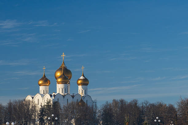 Orthodox cathedral on snowy hill under wide open winter sky. Suitable for religion and seasonal background use.
