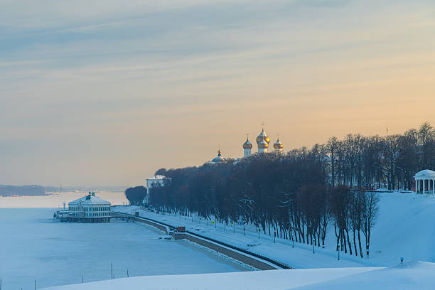 River embankment covered with snow under soft winter sky. Suitable for seasonal and outdoor background use.