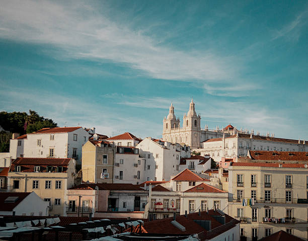 Lisbon Rooftops And Church Towers Basking In Warm Light, Panoramic View Of Terracotta Roofs And Ornate