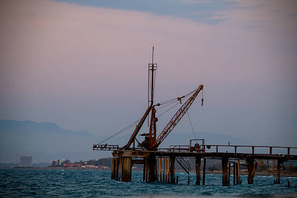 A forgotten industrial wharf bathed in the dying amber light of dusk.