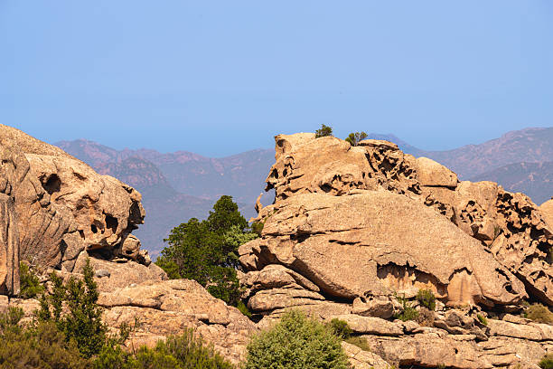 Weathering and erosion creating natural rock faces and shapes in a Corsican landscape