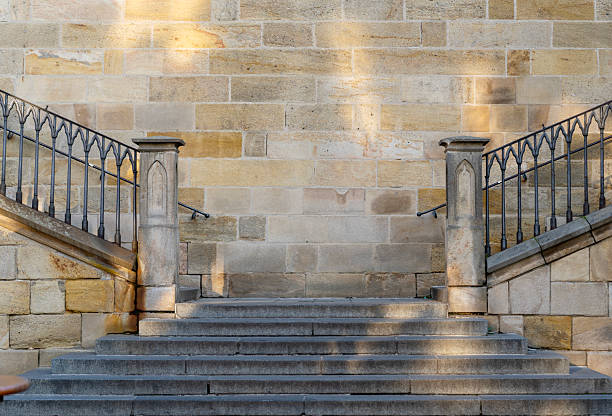 Symmetrical stone staircase detail in Prague, Czech Republic. Historic European architecture with sandstone wall and decorative iron railings. Minimal background concept with copy space