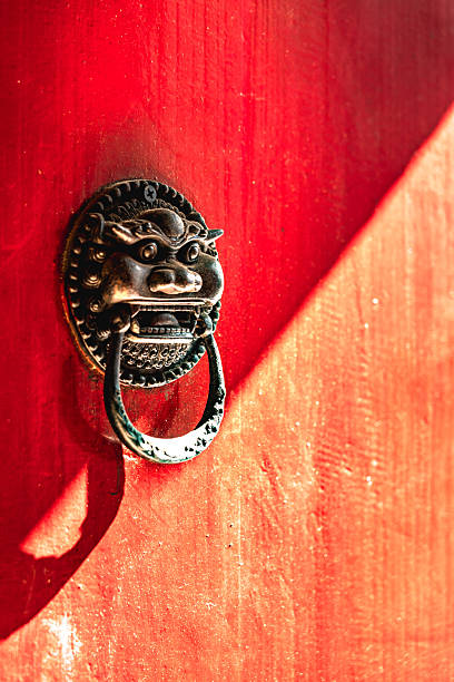 Dragon head door knocker on a traditional chinese red wooden gate