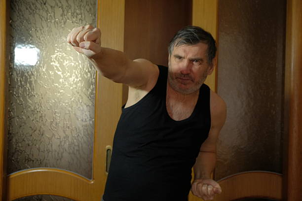Detailed view of a man practicing karate strikes with bare hands at home. Focus on fist position, strength, and traditional martial arts training. A man punching during training.1