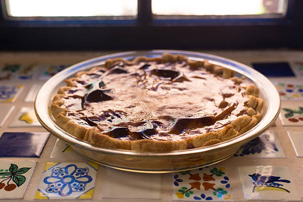 Close Up view of butter tarts with selective focus on crust, blurred background photo.