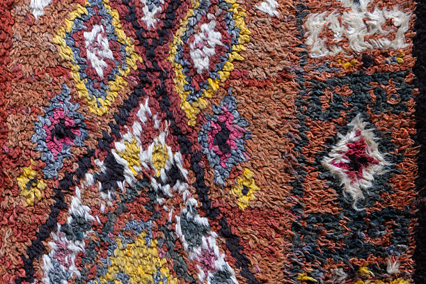 Colorful Uzbek woolen carpet, macro photo featuring traditional patterns of rough handmade fabric