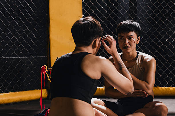 Two fighters in training discuss techniques at arenain the evening light.