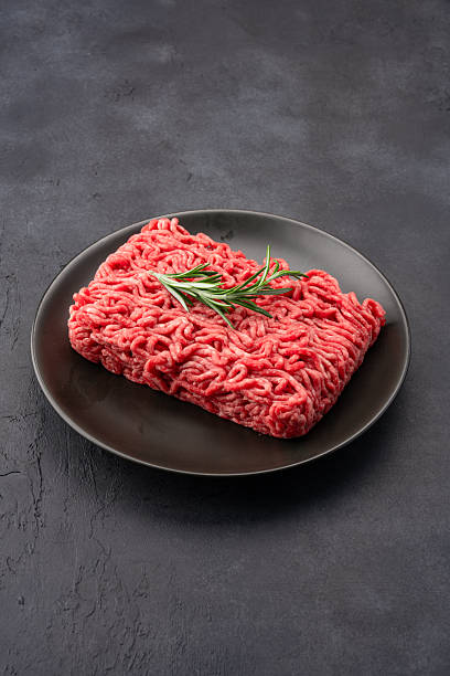 Raw ground meat on black stone table background