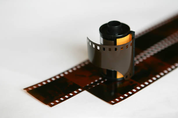 A close-up of a 35mm analog film roll with exposed negatives on a white background, evoking nostalgia for traditional photography and film development processes. Perfect for retro and creative themes