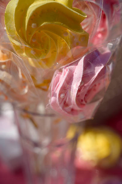 Colorful marshmallow rose lollipops with sprinkles on display outdoors