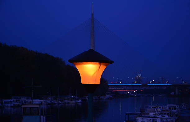 Evening scene in Belgrade (Republic of Serbia), bayou of Sava the river, boats are in dark blue background and a bridge with high concrete pillar is also in background