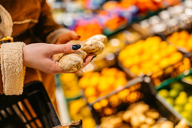 Young Woman Buying A Ginger Plant In A Supermarket