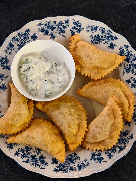 Plate of mini chebureks filled with meat and dipping sauce