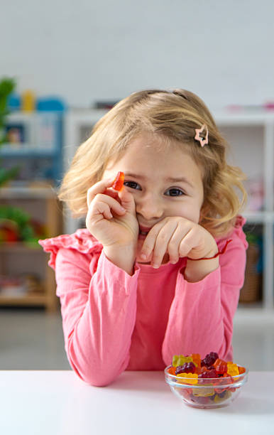 Child eating jelly candies at home. Selective focus.