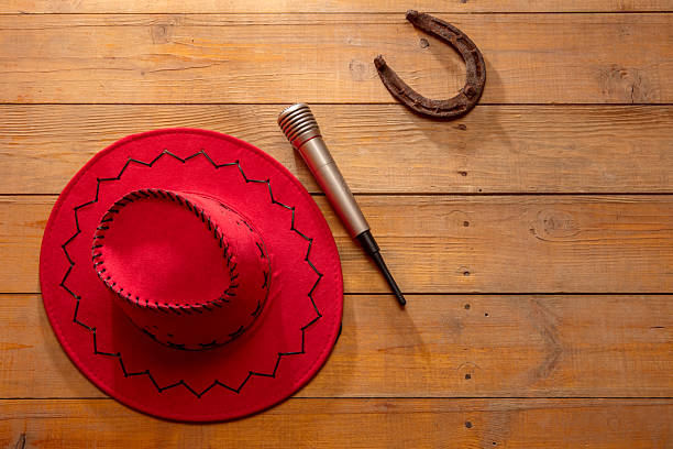 A black hat sits on a white background. The hat is a fedora and is tilted to the side