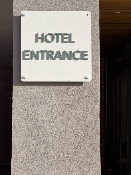 Hotel entrance sign mounted on an exterior building wall, indicating direction for guests