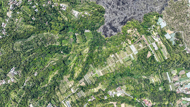 Batur Caldera vibrant patchwork thrives where black lava meets lush green fields. Precise terraces, scattered homes, and winding paths reclaim the volcanic soil.